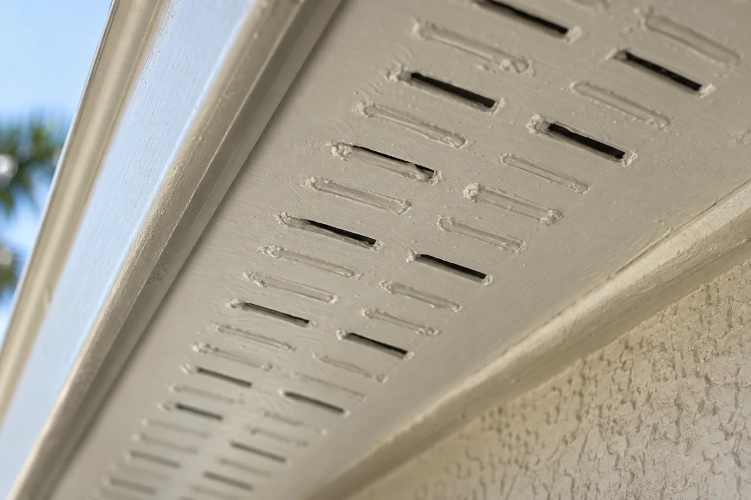 Soffit vent slots under a Florida eave clogged with layers of exterior paint