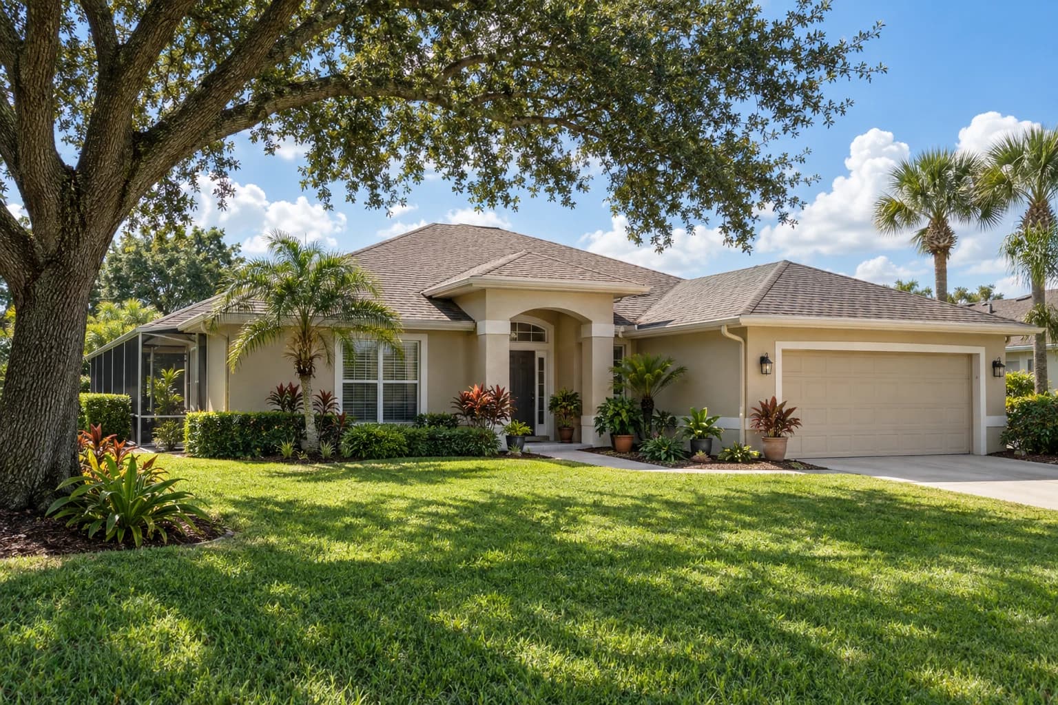 A one-story stucco home with a tile roof and a screened porch in Apopka, with a tall oak and potted foliage plants in the side yard