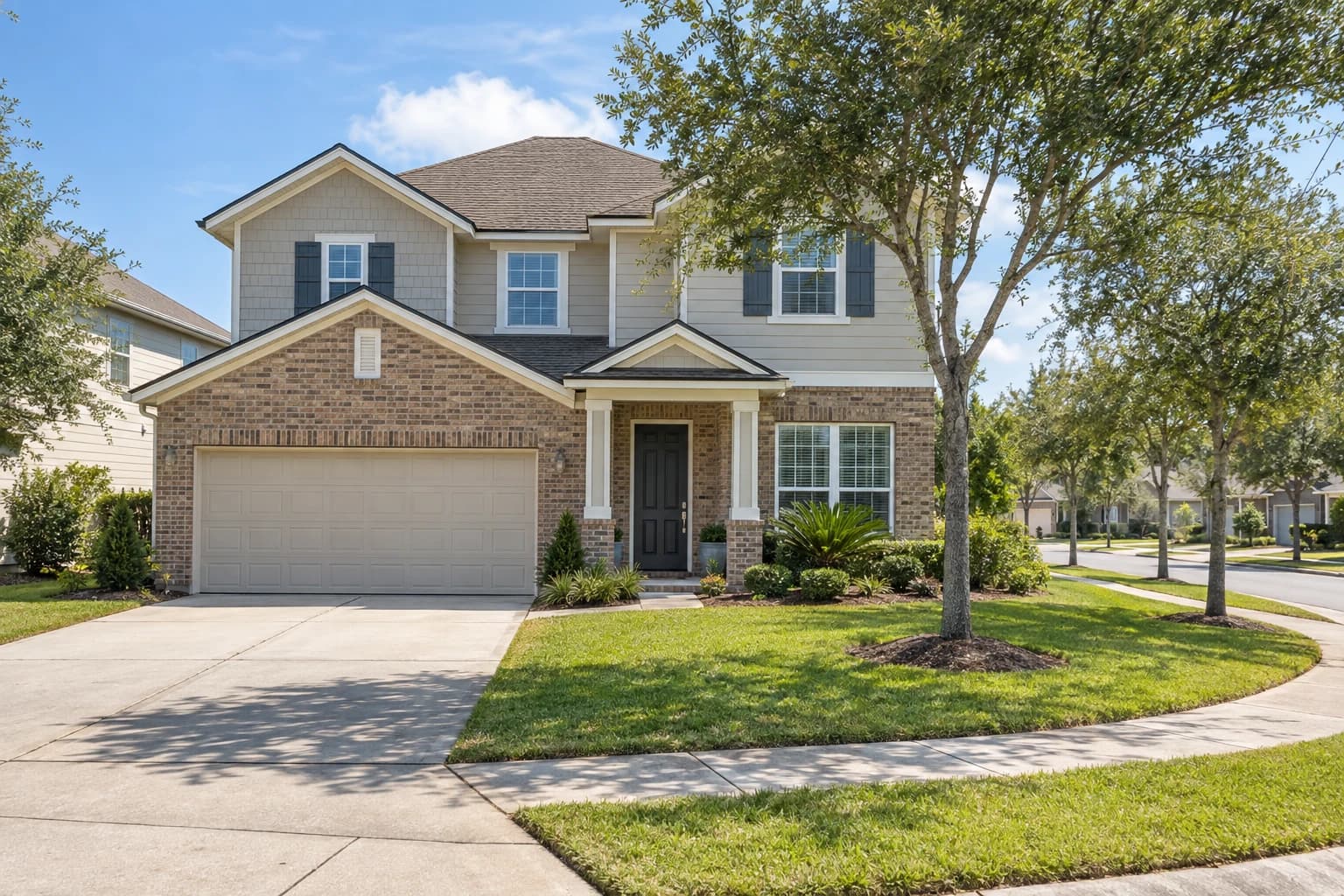 Two-story newer home with a brick and siding front, a two-car garage, and young oaks along a curving St. Johns subdivision street