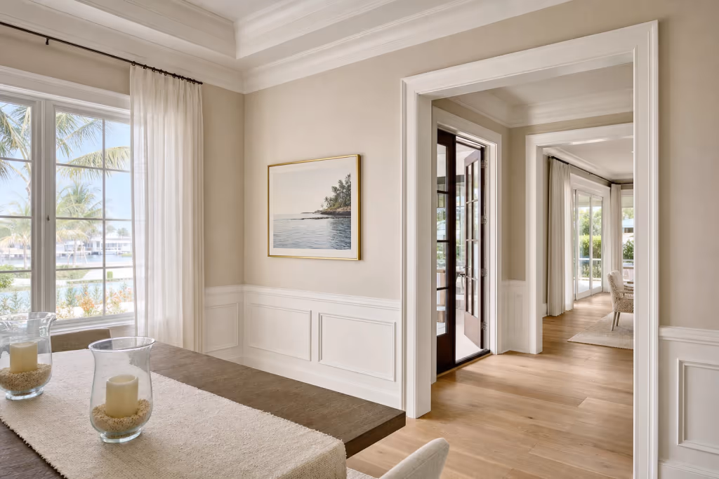 Close view of flawless white crown molding, tall baseboards, and door casing finishing a bright Florida dining room