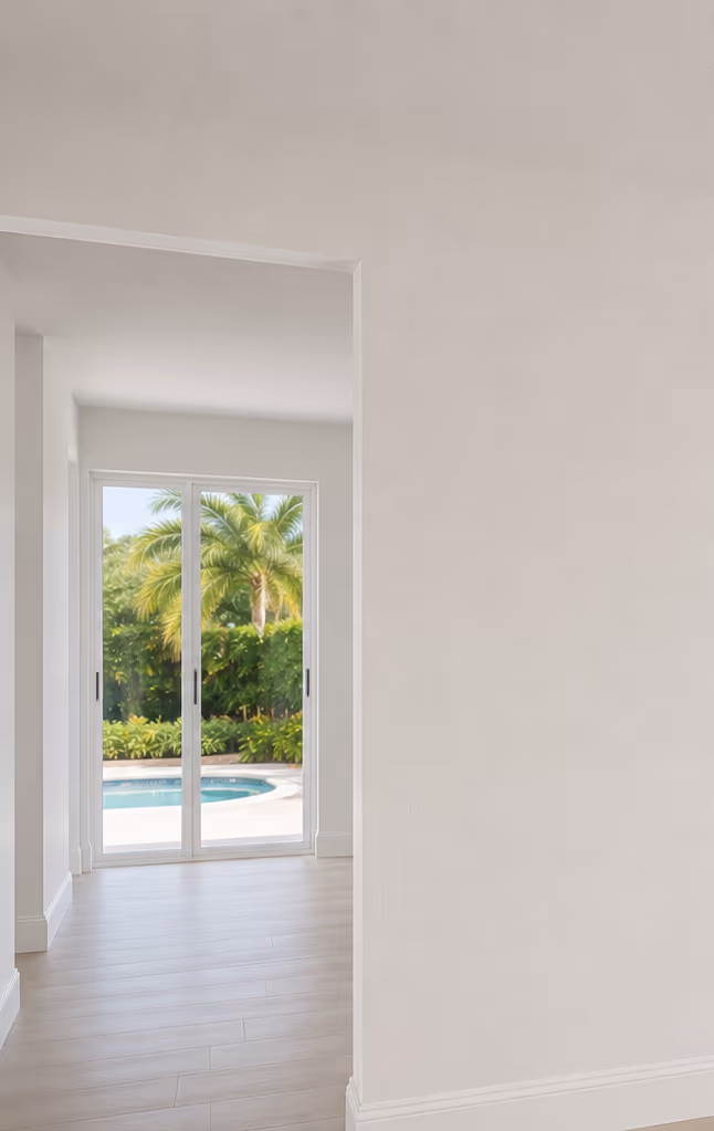 Bright room with a smooth, flawless white wall and a pool view beyond