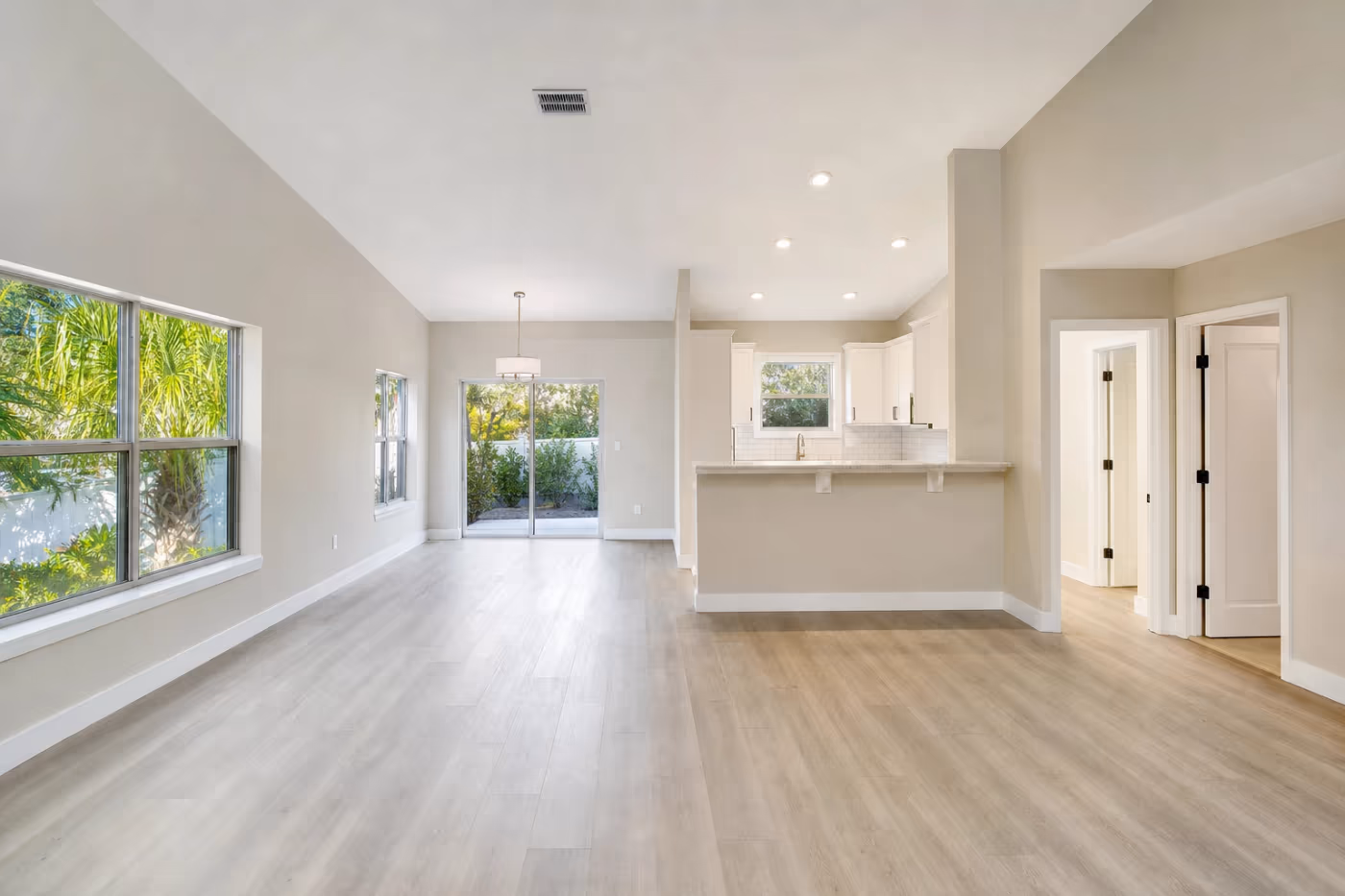 Wide view of a bright Florida rental unit after turnover, an open living and dining area with fresh paint and show-ready finishes