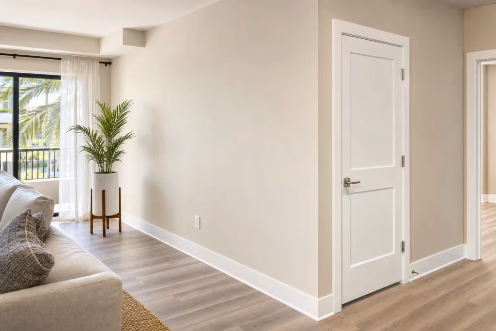 Finished Florida rental living room after a unit turnover, with freshly painted walls, clean baseboards, and updated interior hardware ready for showing