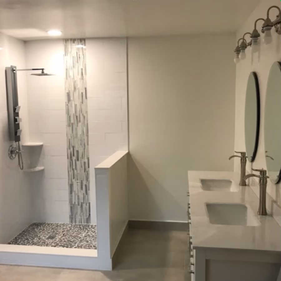 Remodeled bathroom with walk-in tile shower and double vanity, completed by The Handyman Company