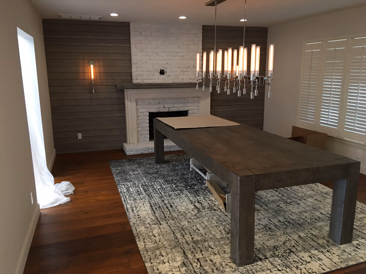 Dining room with a new shiplap accent wall and repainted brick fireplace