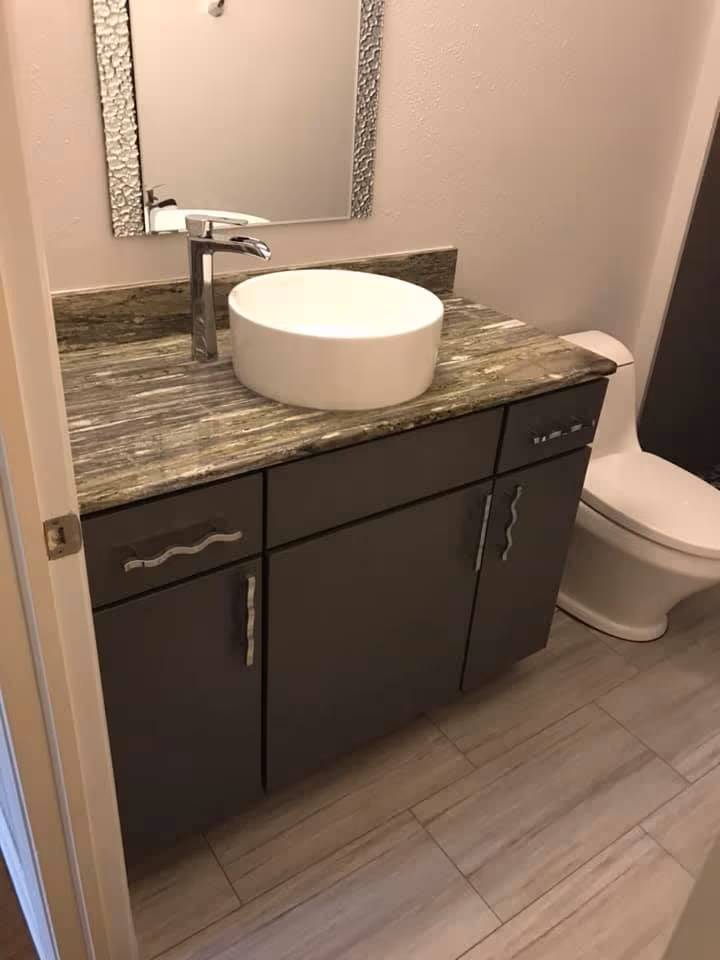 Updated bathroom with a vessel sink vanity and new plank tile floor