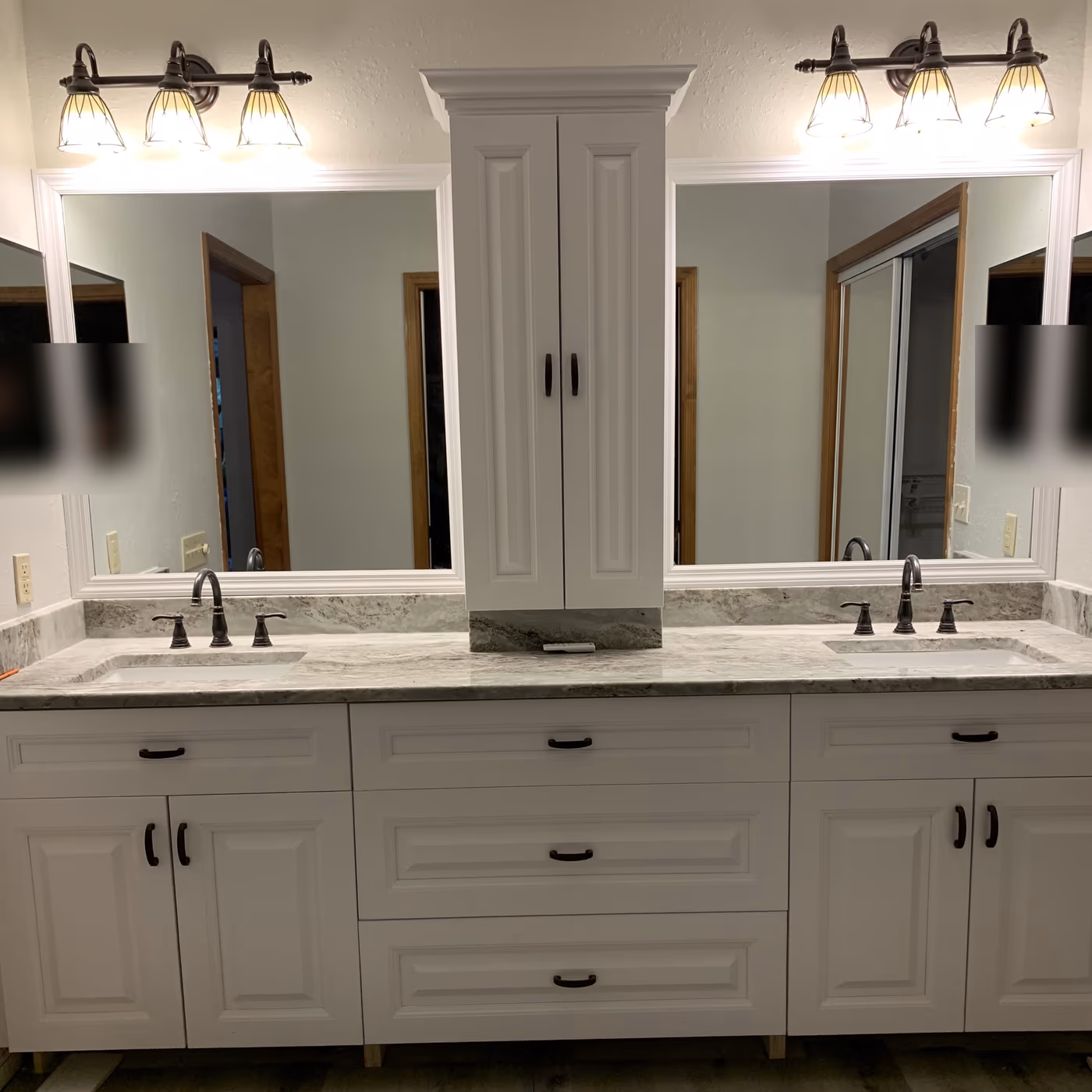 Same vanity wall rebuilt with white cabinets, stone counters, bronze faucets, and new plank flooring