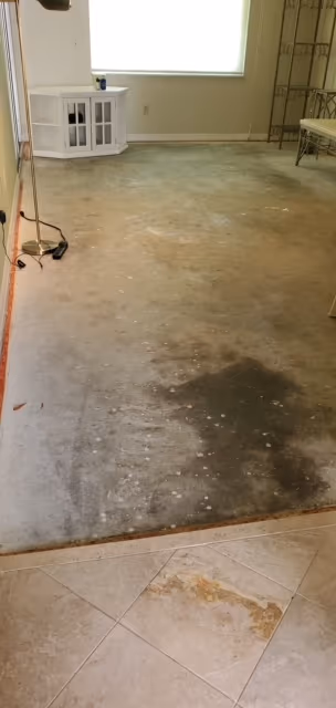 Living room stripped to the bare concrete slab before new flooring