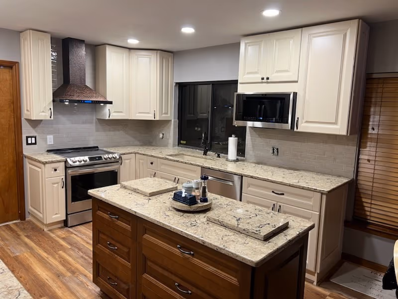 Kitchen range wall with a wood vent hood and subway tile backsplash