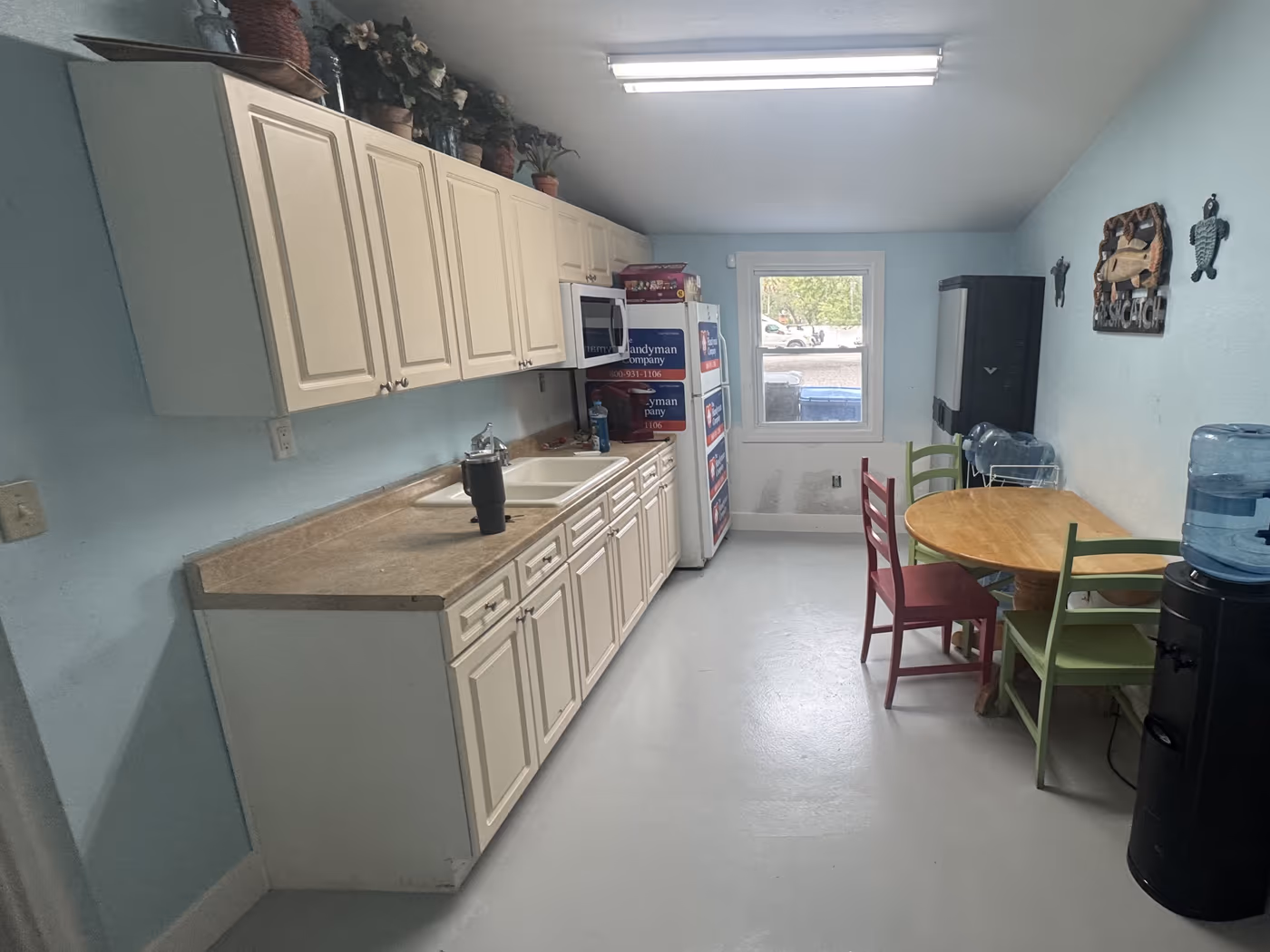 Same break room with a new smooth gray floor finish and the wall base repaired and repainted