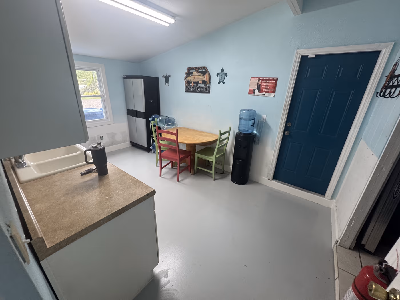 Office break room with a new gray floor finish, repaired wall base, and fresh paint