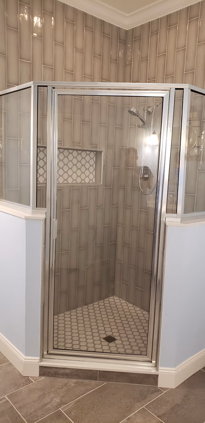 Remodeled walk-in shower with new wall tile and a mosaic accent niche