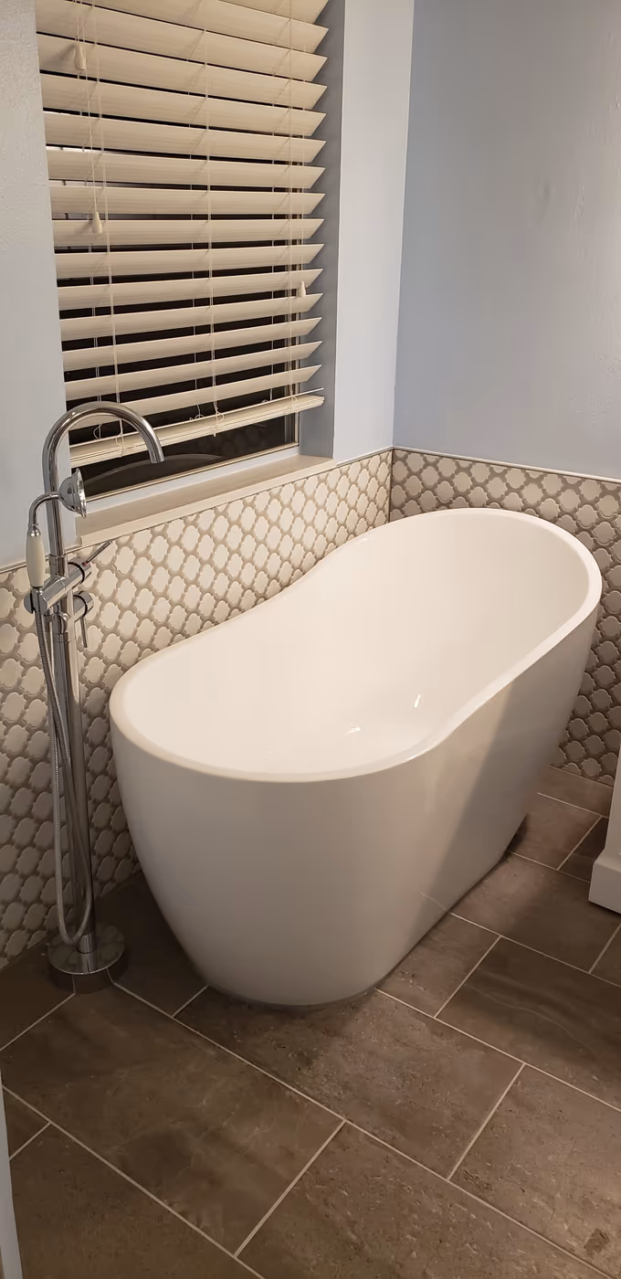 Freestanding soaker tub with new accent tile wall and floor tile