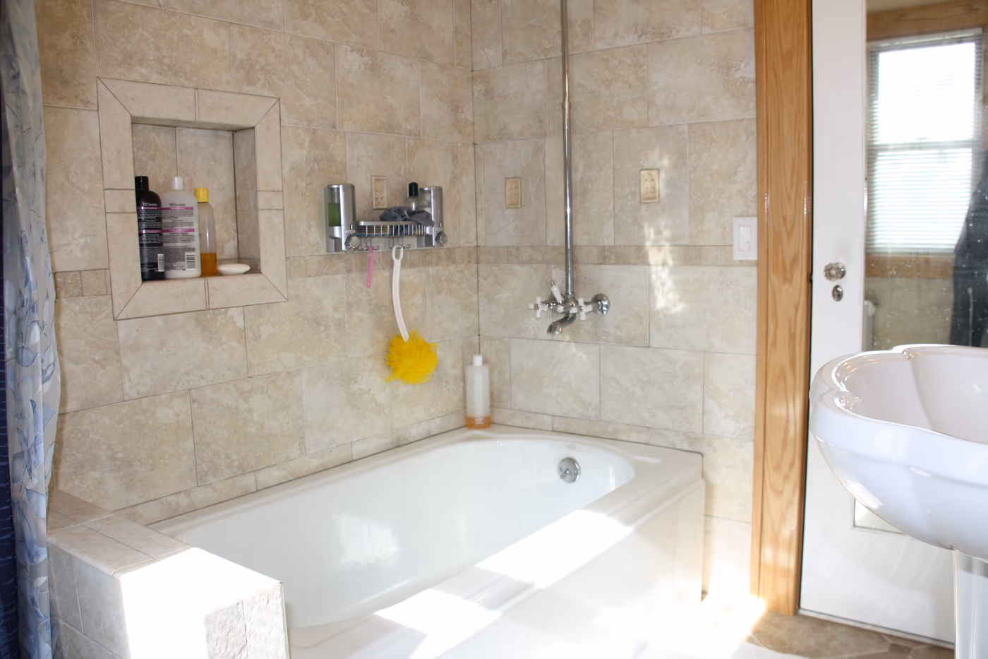 Bathtub with a new full-height tile surround and built-in niche